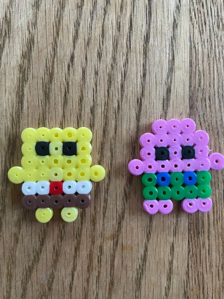 two pieces of plastic bead sitting on top of a wooden table next to each other