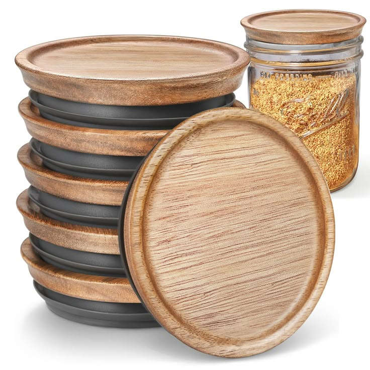 a stack of wooden plates next to a jar