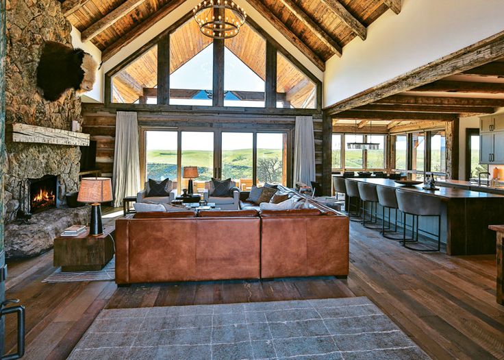 a living room filled with furniture and a fire place in front of a large window