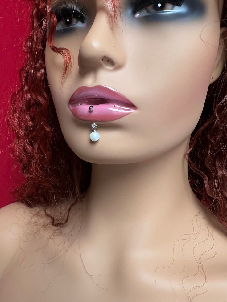 a mannequin head with makeup and red curly hair wearing blue eyeliners