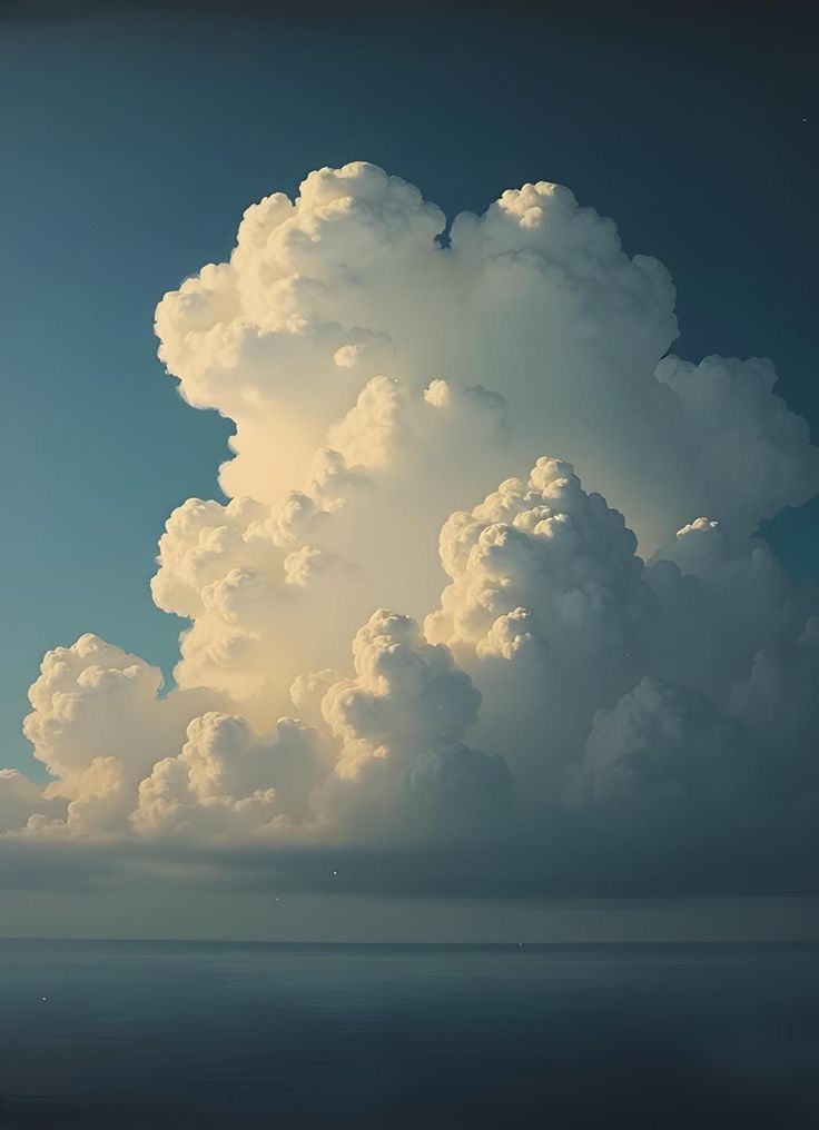 a large cloud is in the sky above the ocean and it appears to be floating