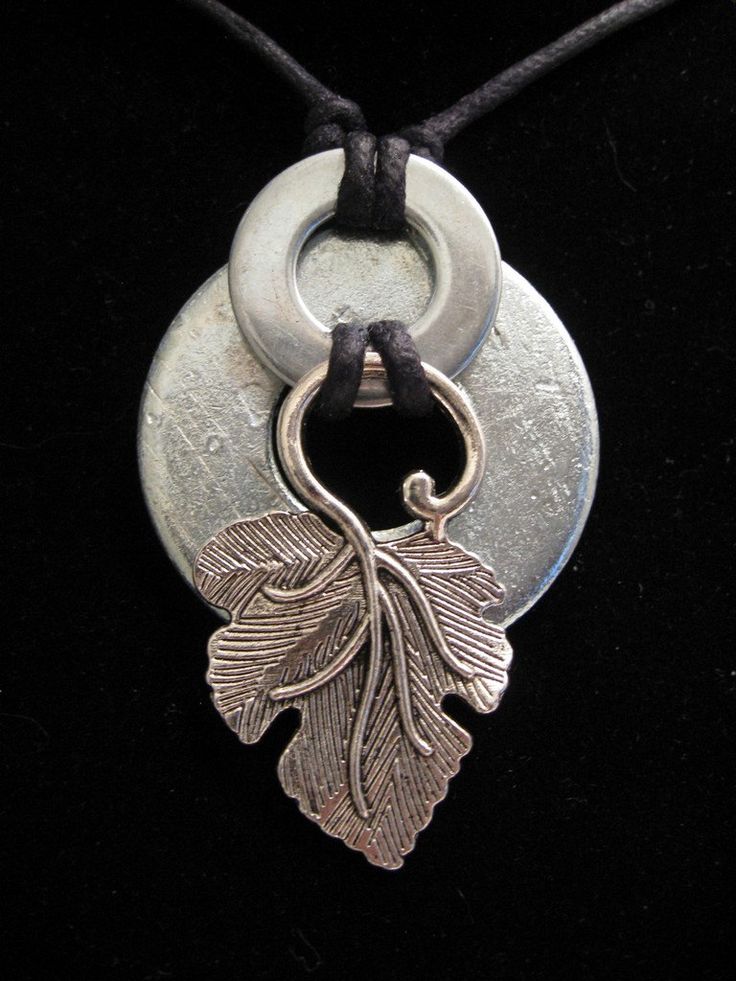 a necklace with a leaf on it and a circle pendant hanging from the front end