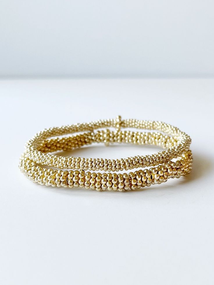 two gold bead bracelets Gold Bracelets With Tiny Beads For Layering, Adjustable Gold Stretch Bracelet For Everyday, Gold Stackable Wrap Bracelet Bangle, Gold Wrap Bracelet With Tiny Beads As A Gift, Gold Stackable Wrap Bracelet, Gold Bracelets With Round Beads For Layering, Gold Hand Wrapped Beaded Bangle Bracelets, Gold Wrap Bracelet For Layering, Everyday Gold Beaded Stretch Bracelet