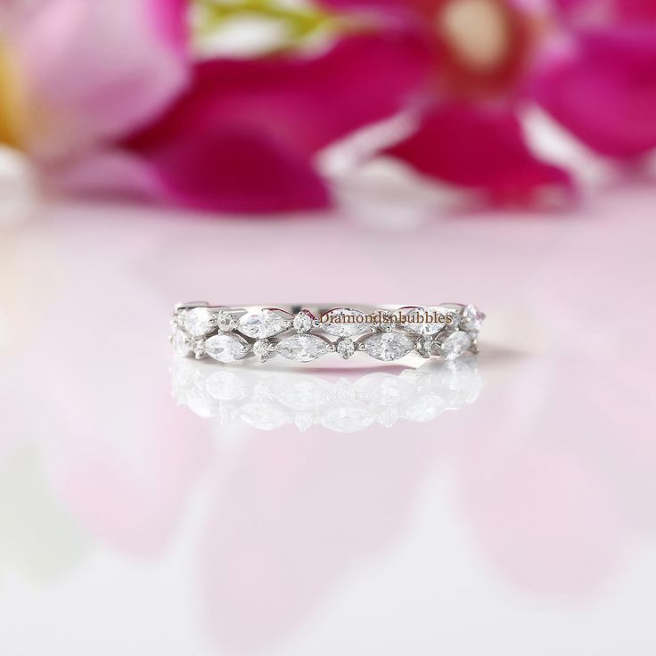 a close up of a wedding ring with flowers in the background