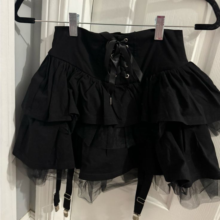 Black Ruffled Mini Skirt With Lace Up Front Widow From Dollskill Size Xs Never Worn High Waist Black Skirt With Ruffles, Black Ruffle Mini Skirt Outfit, Edgy Black Skirted Bottoms, Black High Waist Skirt With Ruffles, Black Ruffled Skort For Party, Black Tiered Skort For Night Out, Black Emo Style Party Bottoms, Black Punk Style Skort For Summer, Emo Style Party Skirt Bottoms