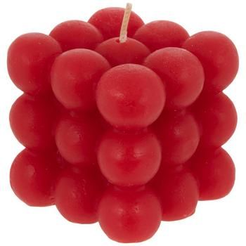 a bunch of red grapes sitting on top of a white table next to a candle