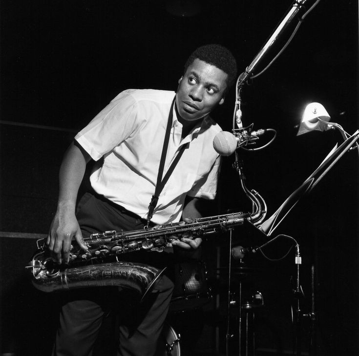 a man in white shirt and tie playing saxophone