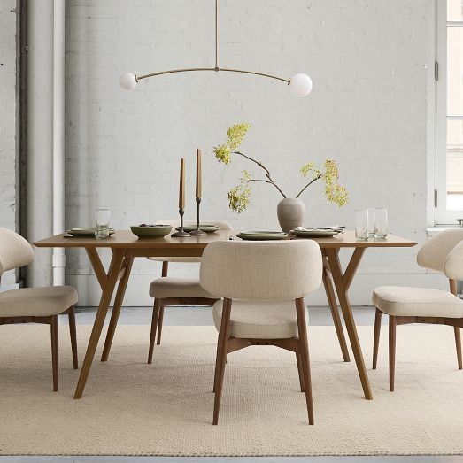 a dining room table with chairs and plates on it