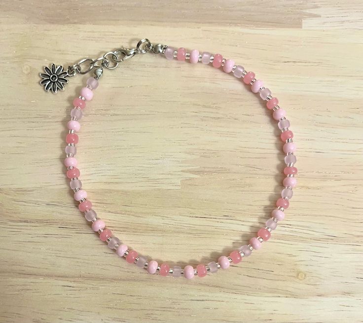 Add that extra pop to any outfit with this coral pink anklet! The anklet is made with an array of pink glass seed beads and finished with a charm of your choice! Colors may vary from image! The anklet is available in a variety of sizes, just message me for custom sizes or an adjusted extender length! There is a size for everyone! :) Every anklet is made with a 1/4" extender for easy adjustability! To extend the life of your new piece avoid direct contact with water and lotions and be gentle when Cheap Pink Beaded Anklets, Pink Anklets For Festival, Cheap Pink Round Bead Anklets, Anklets To Make, Daisy Anklet, Pink Anklet, Seed Bead Anklet, Tiny Bead Bracelet, Pink Beaded Bracelets