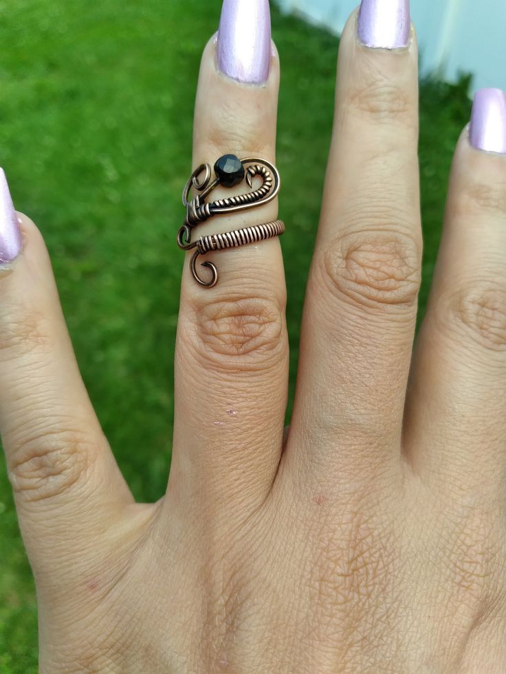 a woman's hand with two rings on it and one ring in the shape of a snake