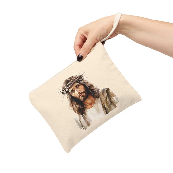 a woman's hand holding a bag with jesus on it