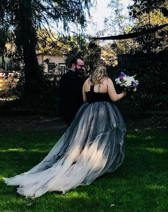 a bride and groom walking through the grass