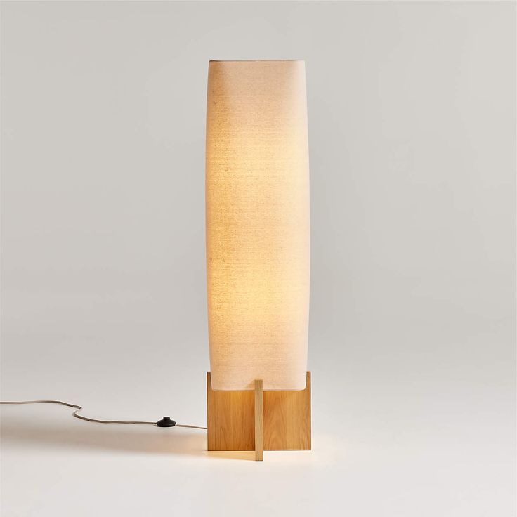 a lamp that is on top of a wooden stand with a cord attached to it