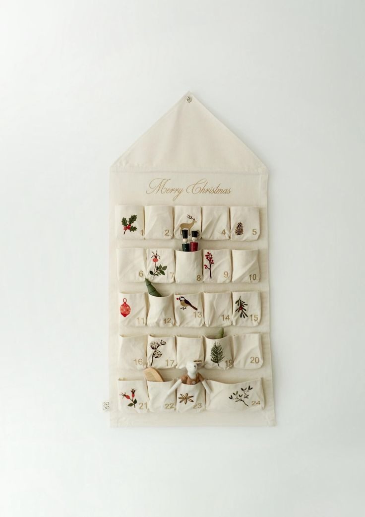 a christmas stocking hanging on a white wall with stockings and bells attached to it