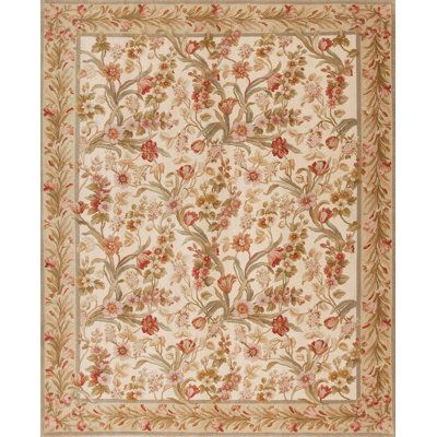 an intricately designed rug with flowers and leaves in beige, red, yellow and green colors