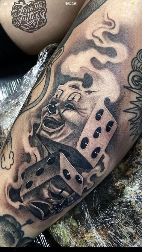 a man with tattoos on his arm holding two dices