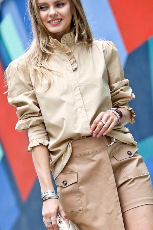 Some shirts simply make you happy the moment you slip them on. This whimsical blouse is one of them. With its ruffle-trimmed collar and sleeves adding a playful touch, this button-down beauty conjures images of twirling through a field of wildflowers on a perfect summer day. Yet its crisp cotton fabric and tailored cut mean it works just as well for that important meeting or client lunch. Versatile, flattering and mood-boosting all at once, this blouse pulls double duty as both a style staple an Casual Blouse With Peter Pan Collar And Ruffles, Trendy Ruffled Collar Top, Ruffled Collar Blouse With Ruffle Hem For Daywear, Fall Puff Sleeve Shirt For Day Out, Fitted Blouse With Smocked Cuffs And Ruffled Collar, Fall Workwear Blouse With Ruffle Hem, Trendy Workwear Blouse With Ruffle Hem, Beige Peter Pan Collar Blouse For Spring, Chic Ruffled Shirt For Fall