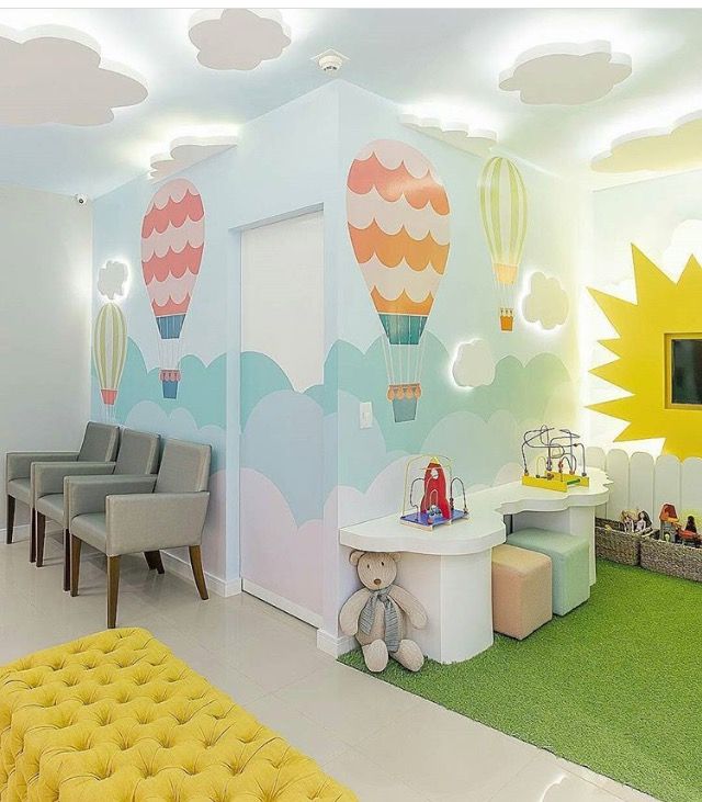 a child's room with hot air balloons painted on the walls and green carpet