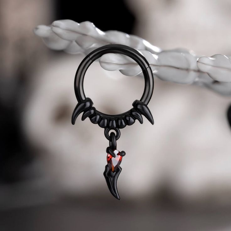 This septum tusk jewelry is mesmerizing. The gothic elements are over the roof. This septum ring features an exquisite design inspired by the graceful and fierce curves of tusks. At the center of the ring sits a vibrant red gem embellished inside a tusk, its deep hue reminiscent of a blood moon gleaming through a cloudy night sky. Get your goth on in gracious style with this septum ring. Tusk Jewelry, Septum Tusk, Cloudy Night Sky, Cloudy Night, Daith Earring, Gothic Elements, Daith Earrings, Septum Jewelry, The Gothic