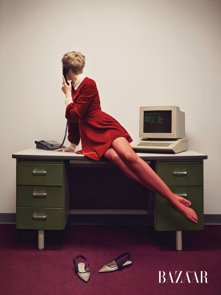 a woman sitting at a desk talking on the phone