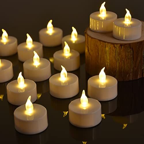 many white candles are lit on a black surface with gold stars around them and one candle is turned upside down