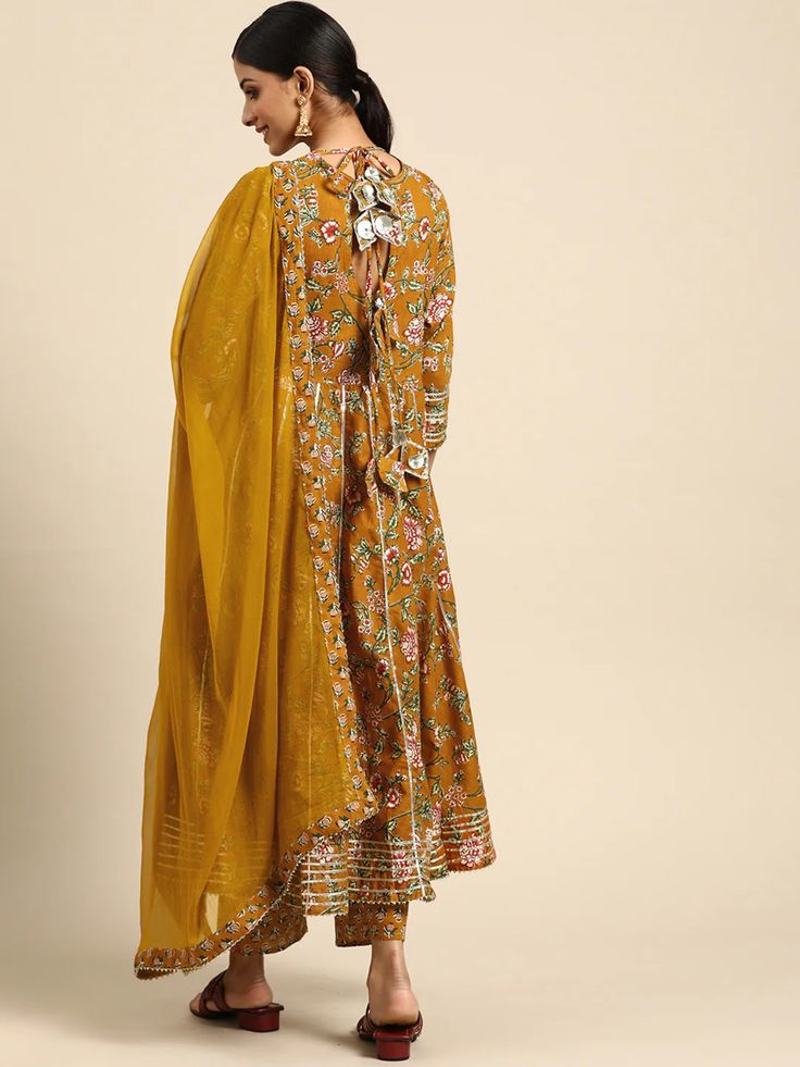 This is a beautiful 3-piece set. The set comes with floral print & gota patti detailing angrakha kurta has round neck, calf length and 3/4th sleeves teamed with printed trouser pants and a chiffon dupatta. Total No of Set-3 Kurta Fabric: Cotton Bottom Fabric - Cotton Dupatta Fabric-Chiffon Work Done - Gota Patti & Print Detailing. Sleeve Length: 3/4th Sleeves Color: Yellow Occasion: Party Wear Washing Instructions: Hand Wash or Dry Clean Spring Festive Salwar Kameez With Gota Work, Yellow Floral Print Kurta, Yellow Bollywood Style Floral Kurta, Bollywood Style Kurta With Gota Work For Spring, Spring Salwar Kameez With Gota Work And Long Sleeves, Spring Long Sleeve Salwar Kameez With Gota Work, Festive Designer Floral Print Kurta, Floral Print Traditional Wear For Spring Festivals, Floral Print Traditional Wear For Festive Spring