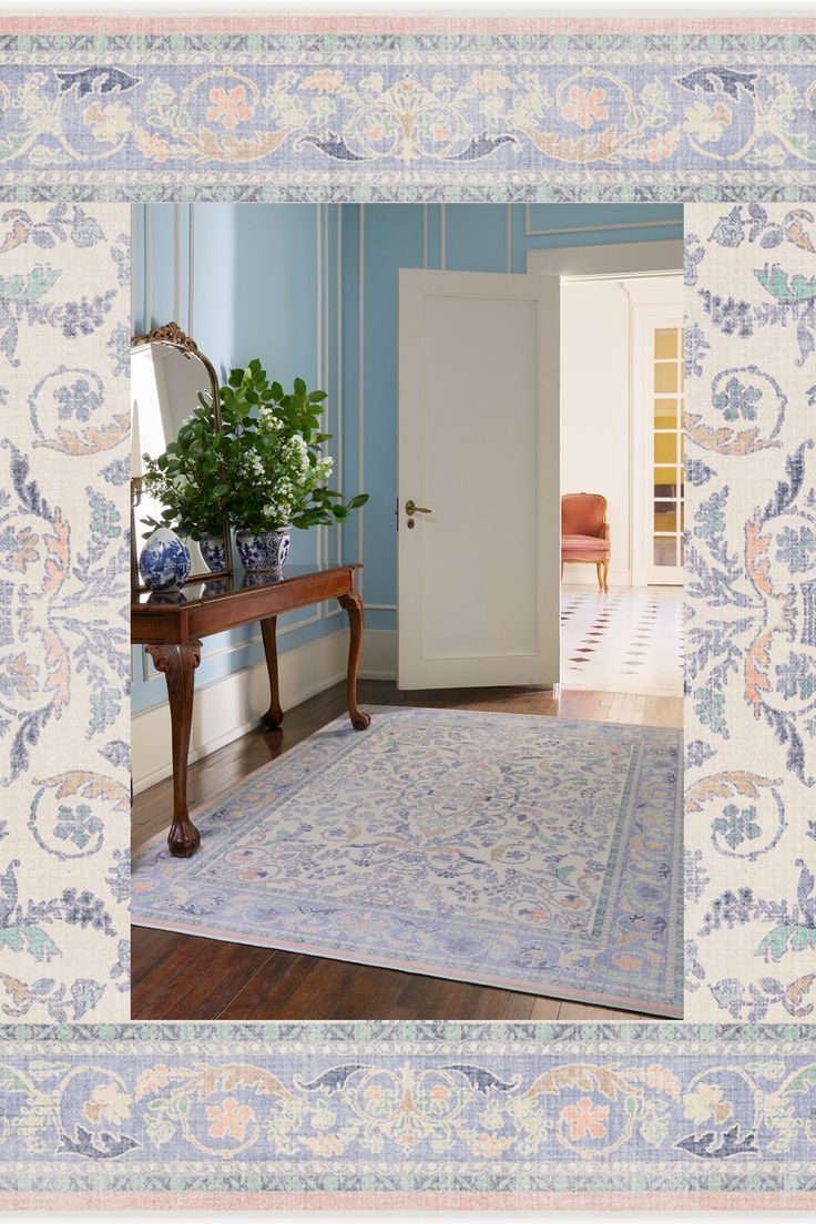 a blue and white room with a rug on the floor, potted plant in front of door