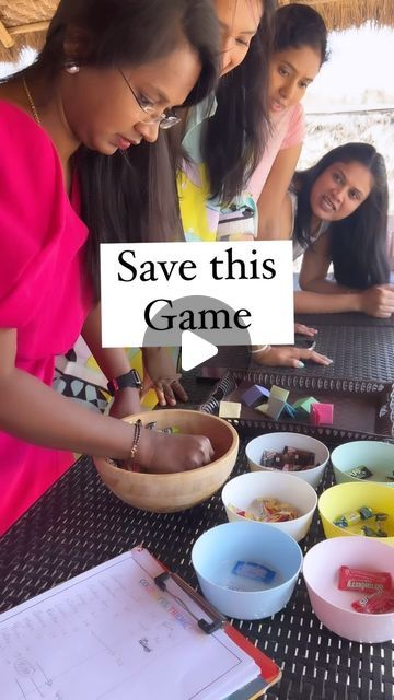 three girls are standing around a table with some food on it and the words save this game above them