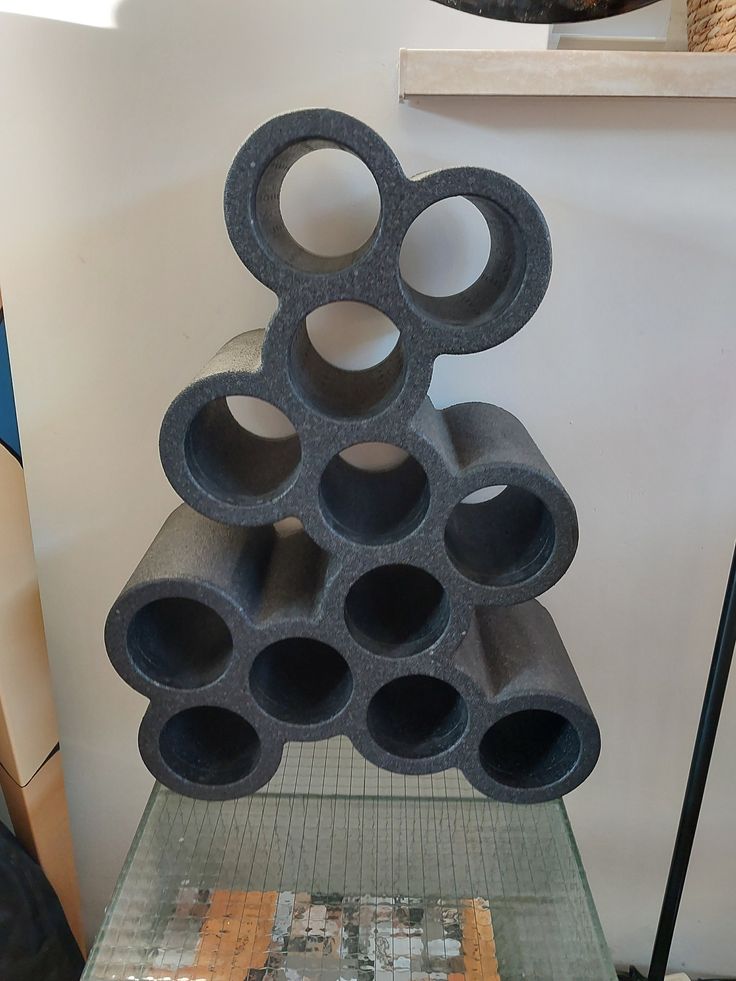 a stack of concrete tubes sitting on top of a glass table