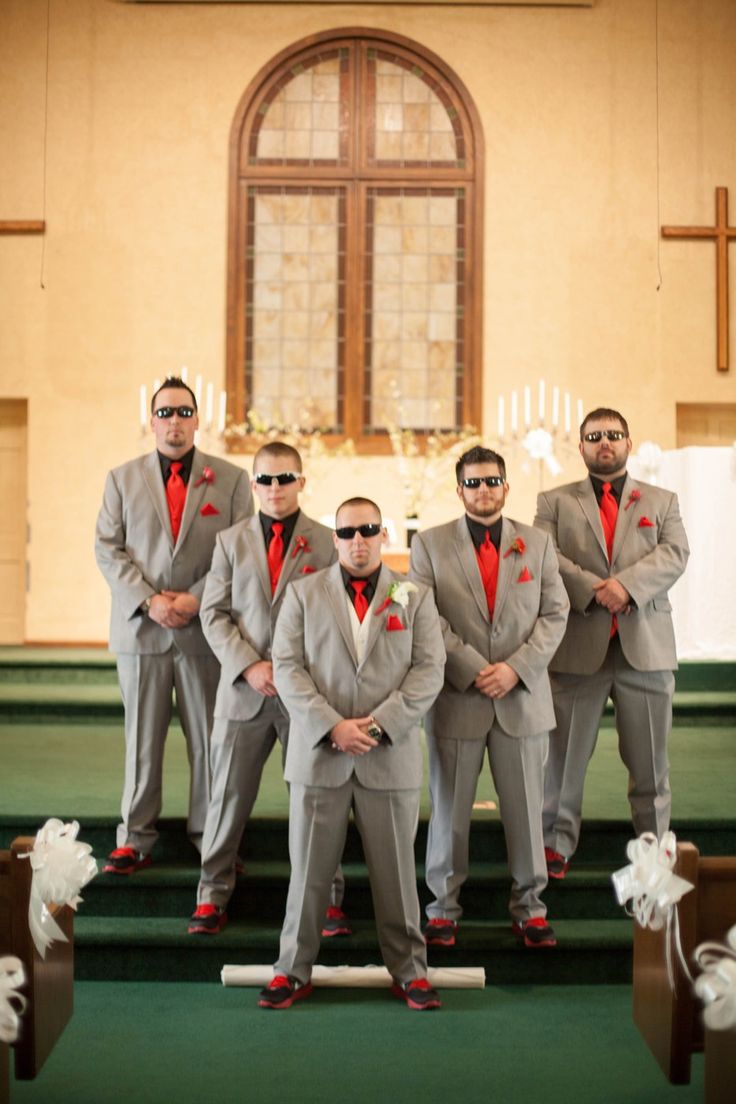 a group of men standing next to each other in front of a church pews