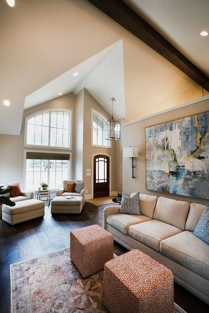 a living room filled with furniture and a large painting hanging on the wall above it