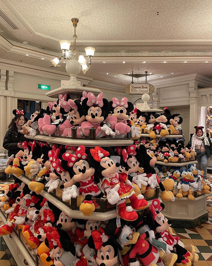 many stuffed animals are stacked on top of each other in a room with checkered flooring