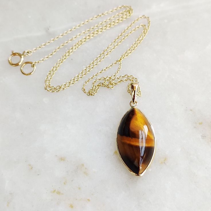 "You can choose your own gem in my store. Let me know if you would like to see options Gemstone: Brown YellowTiger Eye Gold Purity : Guaranteed 14kt pure GOLD Gem weight 9.60 carats Gem shape: Marquis Cabachon shape Gold weight: 0.56 grame Total weight: 2.48 grame The Gemstone in this pendant is ethically sourced and is exploitation free. Brown Yellow Tiger Eye is a beautiful Gemstone of patterns like no other Gemstone. Please note that the pendant is made with absolutely pure 14kt Gold. Pendant Yellow Gold Gemstones For Gift, Fine Jewelry Style, Oval 14k Gold Gemstones For Gift, Oval 14k Gold Gemstones As Gift, Yellow Gold Marquise Necklace For Gift, Hallmarked Yellow Gold Gemstones For Gift, 14k Yellow Gold Gemstones For Gift, Gold Pendant Gemstones As A Gift, Fine Jewelry Gemstone Pendant For Gift, Gold Pendant Gemstones For Gift