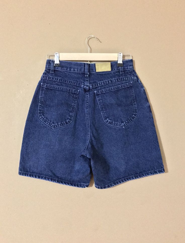 High waisted 90s Lee denim shorts. Made in the USA. Dark blue denim wash. Shorts are in great condition with minor signs of previous wear. Soft and comfy worn in denim perfect for cutoffs or as is. Perfect with a simple tee and sneakers or sandals. Cut them off yourself for the perfect length! Check out my shop 'TheBarnLadder' for additional reviews and feedback Measurements (taken zipped or buttoned up and laid comfortably flat) Size 10M Waist 28 Hips 39-40 Length 18 Inseam 6 Rise 12 Top leg ci Dark Blue Denim Shorts Outfit, 90s Style Denim Blue Cotton Shorts, 90s Jean Shorts, Blue Denim Shorts Outfit, 90s High-waisted Denim Jean Shorts, 90s Denim Blue Shorts With Pockets, Vintage Dark Wash Denim Shorts, Levi High Waisted Shorts, 90s High-waist Cotton Jean Shorts