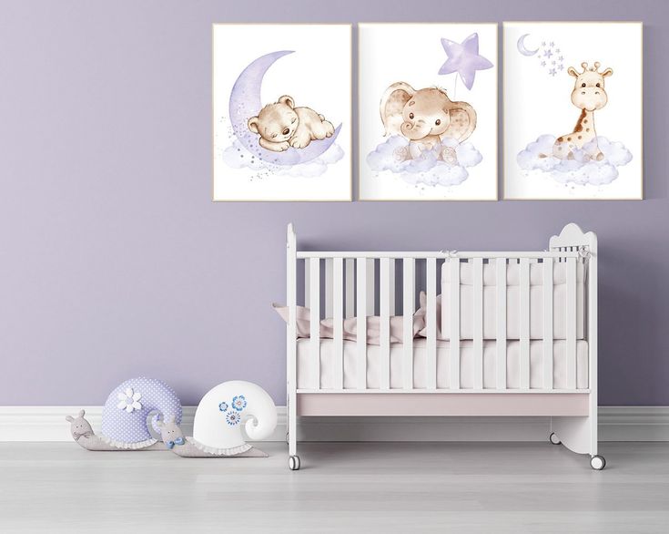 a baby's room with purple walls and two pictures on the wall, including a crib