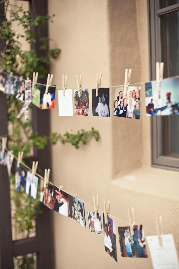 several photos hanging on clothes pins with clothes pins attached to the clothes pegs in front of a building