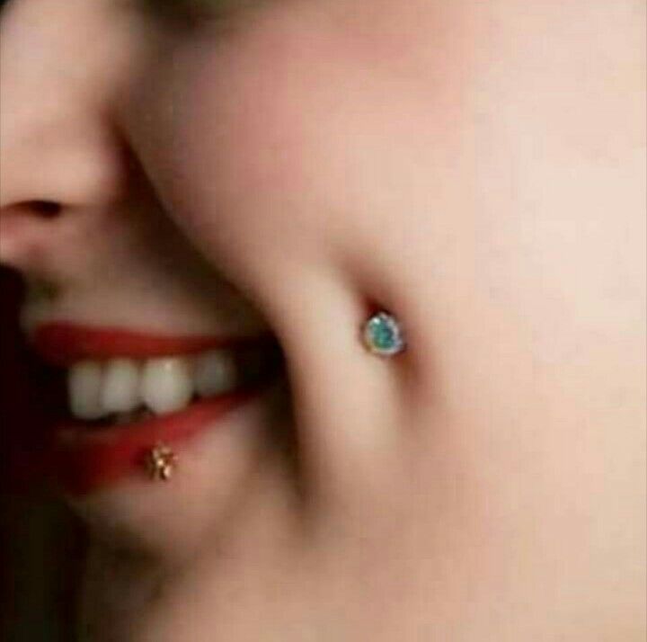 a close up of a person wearing some kind of earring on their left side