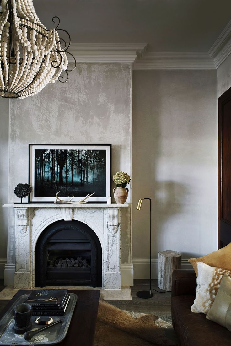 a living room with a fire place and a chandelier hanging from the ceiling