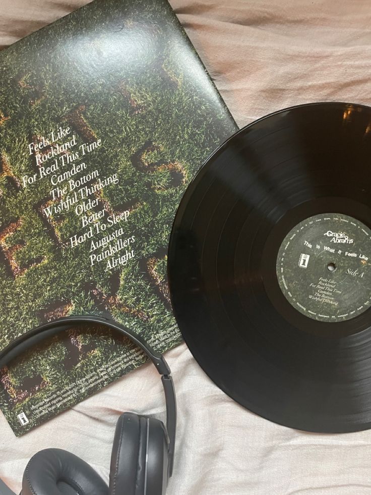 an old record and headphones on a bed