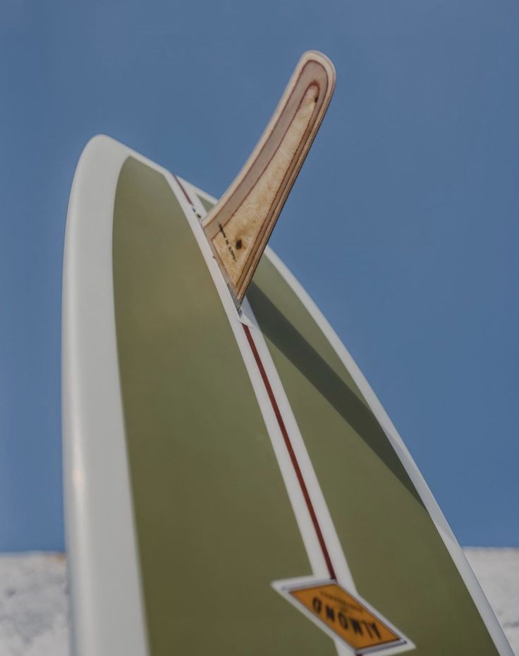 a surfboard with a stick sticking out of it's back end, against a blue sky