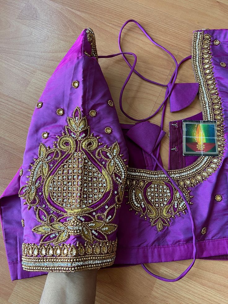 This is a beautiful piece of art work which I have designed to match almost any saree. Wearing this blouse can cheer up any new or old beautiful saree from our closet. Color:Silver silk fabric with gold handwork  Material: soft silk, Beads, kundans  Blouse size- size can be adjusted to 34-46 inches chest Embroidered Purple Dola Silk Blouse Piece, Purple Blouse Piece With Intricate Embroidery, Purple Art Silk Traditional Wear With Intricate Embroidery, Diwali Purple Blouse With Intricate Embroidery, Purple Saree With Intricate Embroidery For Festivals, Purple Embroidered Saree For Festivals, Embroidered Art Silk Purple Blouse Piece, Intricate Embroidery Purple Blouse Piece For Wedding, Embroidered Purple Art Silk Blouse Piece