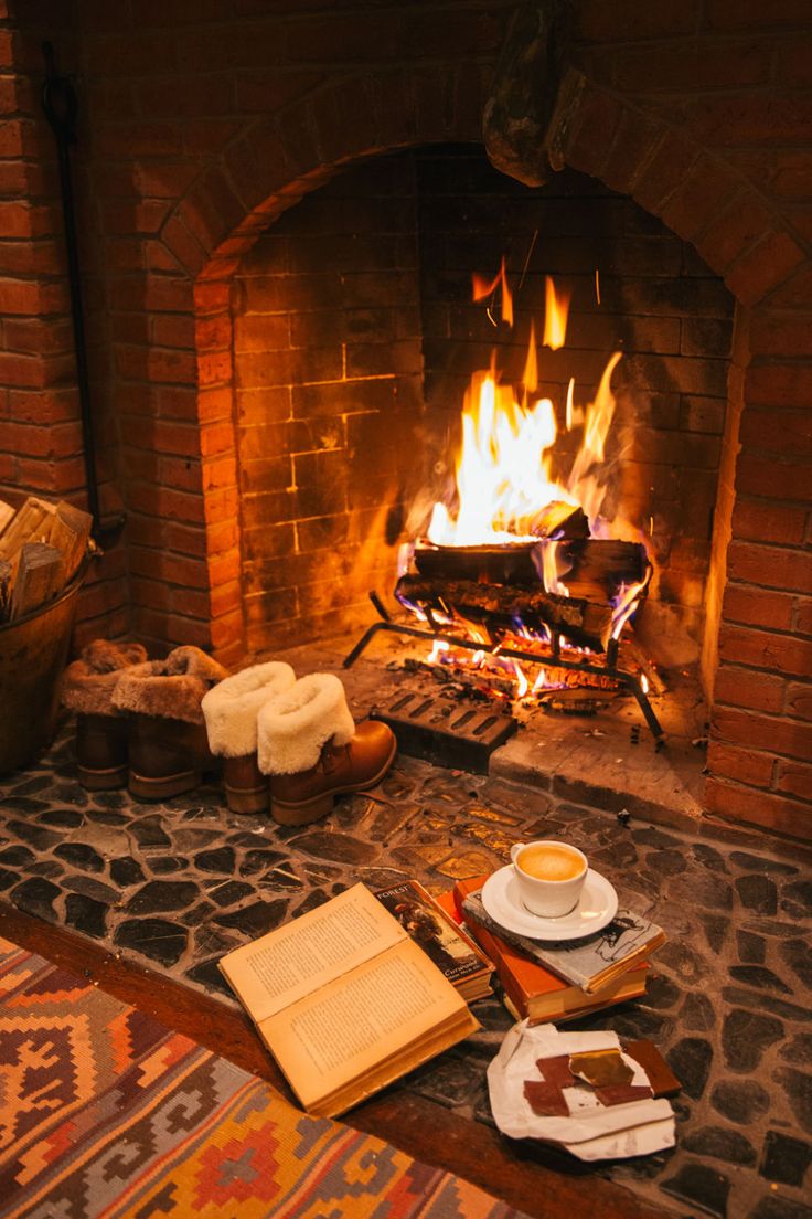 a fire place with food and drinks on the table in front of an open fireplace