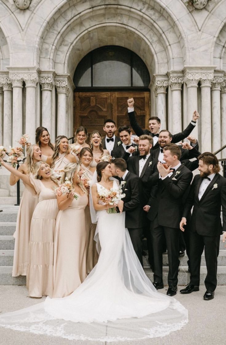 a large group of people standing in front of a building posing for a photo together