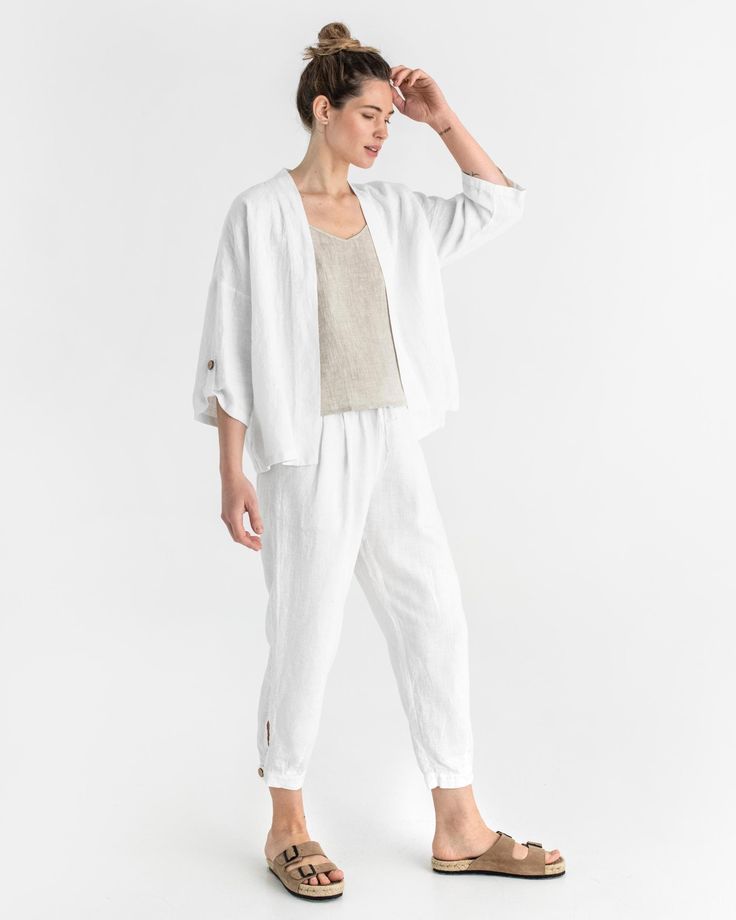 This throw-on linen kimono jacket BANOS in white offers an effortlessly chic look with its open front, shawl collar, and relaxed dropped shoulders. The 3/4 sleeves feature decorative flaps at the bottom, which can be secured with coconut buttons, adding a unique touch to the design. Details: * Loose fit * Shawl collar * Non-closable * 3/4 sleeve length * Dropped shoulder design * Bottom of the sleeves that fastens with decorative coconut buttons * Centre back length: 23" (58cm) * 1st model is we White Linen Outerwear, White Casual Cardigan With Kimono Sleeves, Casual White Cardigan With Kimono Sleeves, White Relaxed Fit Kimono For Loungewear, Casual White Kimono For Spring, Casual White Spring Kimono, Casual White Relaxed Fit Kimono, White Relaxed Fit Cardigan For Spring, White Relaxed Fit Summer Cardigan