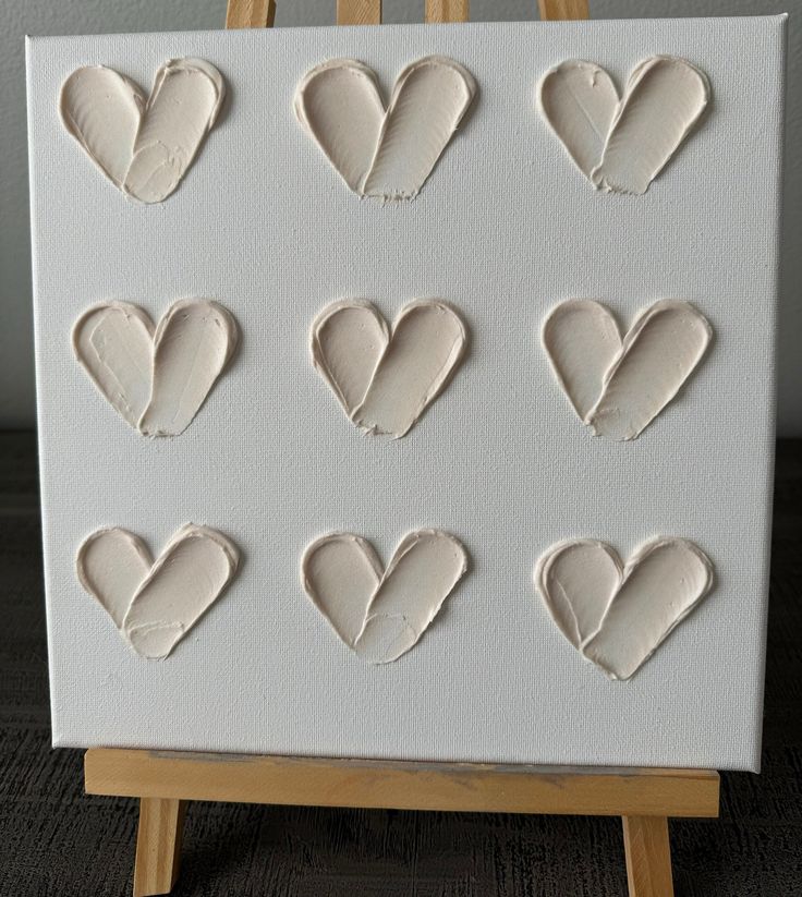 an easel with twelve hearts carved into it