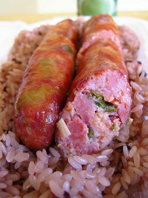 two sausages wrapped in rice on a plate