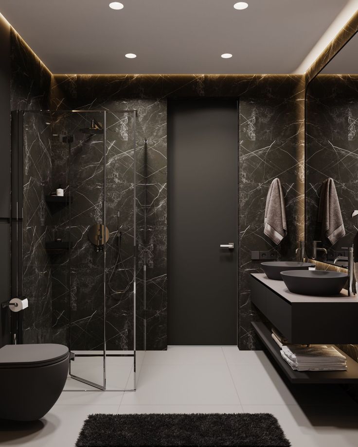 a modern bathroom with black marble walls and flooring, along with a large walk in shower