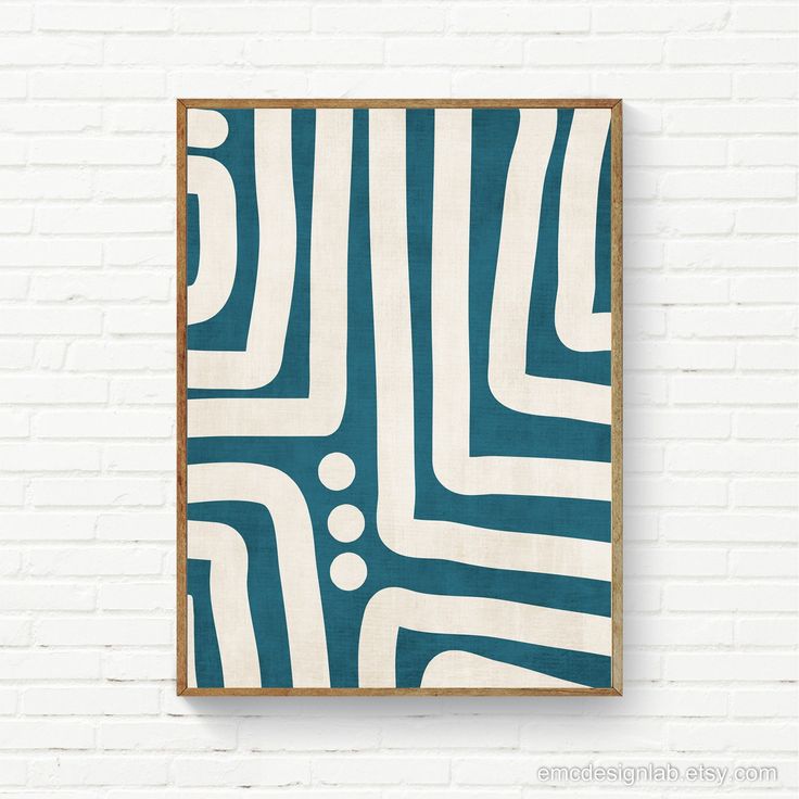 a blue and white abstract painting hanging on a brick wall next to a wooden frame