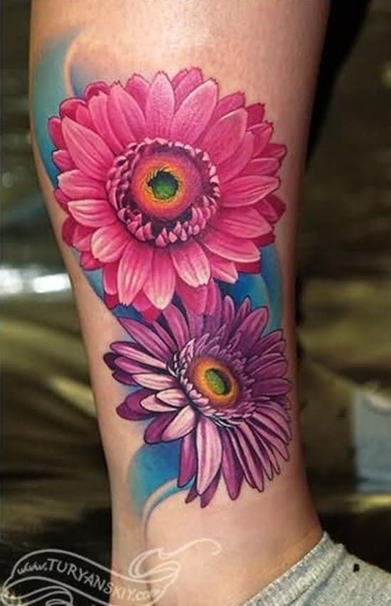 a woman's leg with pink flowers on the side of her body and an eye