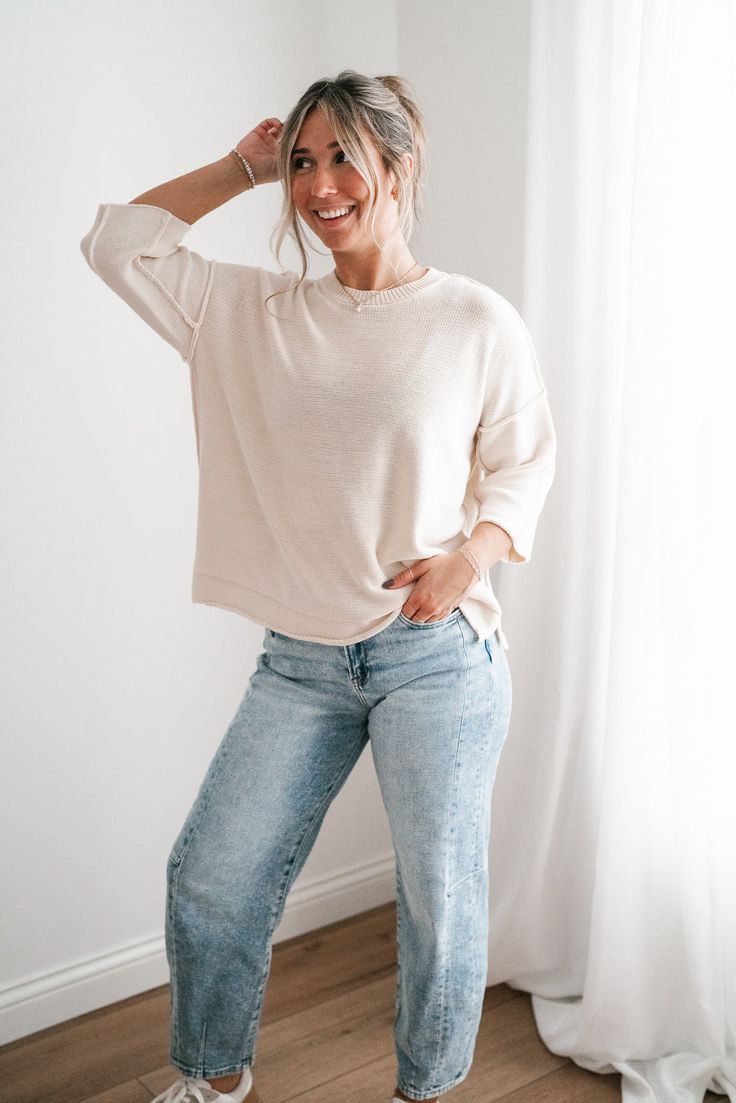 Elevate your casual wardrobe with the Evening Stroll Sweater Top, a versatile and chic piece that transitions effortlessly from day to night. This top is crafted in a soft cream knit that exudes subtle elegance. Its crew neckline is complemented by wide ribbed detailing, while the dropped shoulder seams and slouchy sleeves add to its laid-back vibe. The cozy knit texture gives it a timeless, casual charm, making it perfect for layering or wearing solo on cool evenings. Fabric: 100% Cotton Produc Versatile Relaxed Fit Knit Top For Loungewear, Relaxed Cream Tops For Fall, Chic Relaxed Fit Knit Top For Everyday, Beige Knit Top For Loungewear, Effortless Relaxed Fit Sweater For Everyday, Effortless Relaxed Fit Everyday Sweater, Cream Soft Knit Tops For Layering, Chic Soft Knit Top With Relaxed Fit, Oversized Knit Top